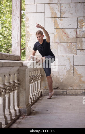 Per tutta la lunghezza della giovane pratica di danza di ringhiera in edificio storico Foto Stock