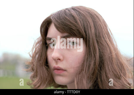 Close-up verticale di grave giovane donna con capelli castani Foto Stock