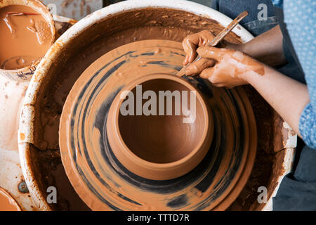 Immagine ritagliata della donna forma di stampaggio sulla ruota in ceramica Foto Stock