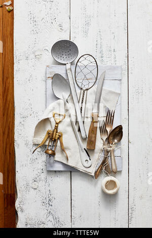 Angolo di alta vista di utensili da cucina con cavatappi e filettatura sul tavolo di legno Foto Stock