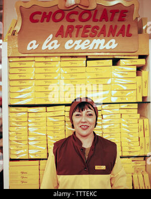 ARGENTINA, Bariloche, sorridente signora con la pila di pranzo cioccolatini al Turista negozio di cioccolato. Foto Stock