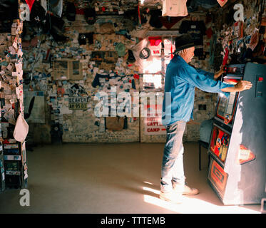 AUSTRALIA, William Creek, l'Outback, profilo di uomo maturo con jukebox nel William Creek Bar Foto Stock