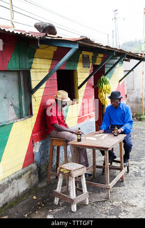 Giamaica, Port Antonio. Giuseppe " polveri " Bennett e Derrick "Johnny' Henry del Mento Band, il Jolly ragazzi gioca domino a Willow Wind Bar. Foto Stock