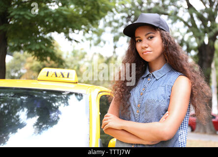 Femmina taxi driver nei pressi di auto Foto Stock