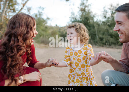 Uomo che guarda un allegro madre con la figlia Foto Stock