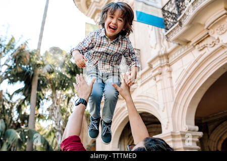 Basso angolo di visione del padre figlio di lancio in aria mediante la costruzione di Foto Stock