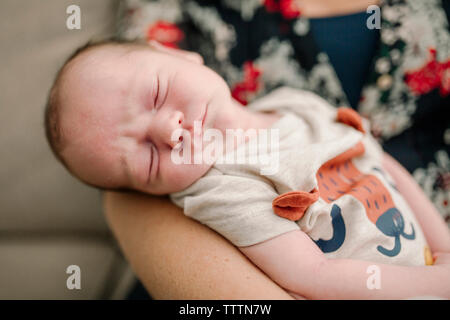 Close-up di madre che trasportano carino neonato figlio che dorme a casa Foto Stock