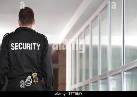 La sicurezza uomo in piedi indietro nel corridoio Foto Stock
