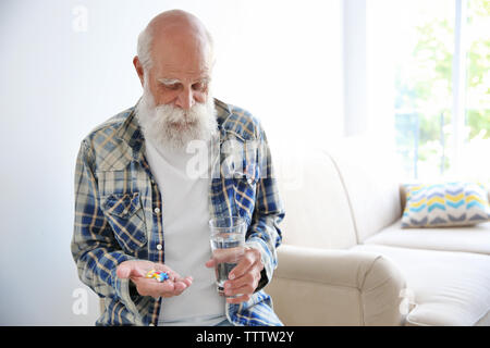 Senior uomo prendendo pillole Foto Stock