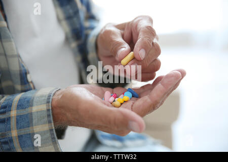 Senior uomo prendendo pillole, primo piano Foto Stock