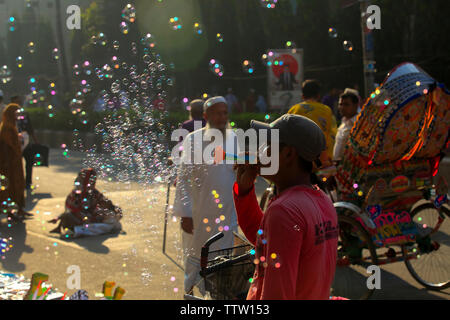 Un hawker soffiando bolle di sapone su strada in occasione di Eid ul Azha. Dacca in Bangladesh. Foto Stock