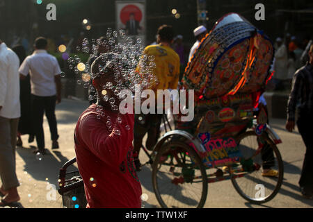 Un hawker soffiando bolle di sapone su strada in occasione di Eid ul Azha. Dacca in Bangladesh. Foto Stock