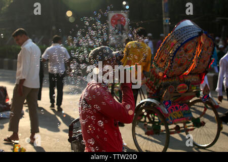 Un hawker soffiando bolle di sapone su strada in occasione di Eid ul Azha. Dacca in Bangladesh. Foto Stock