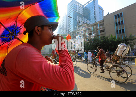 Un hawker soffiando bolle di sapone su strada in occasione di Eid ul Azha. Dacca in Bangladesh. Foto Stock