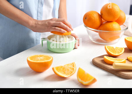 Mani femminili spremendo il succo d'arancia, primo piano Foto Stock
