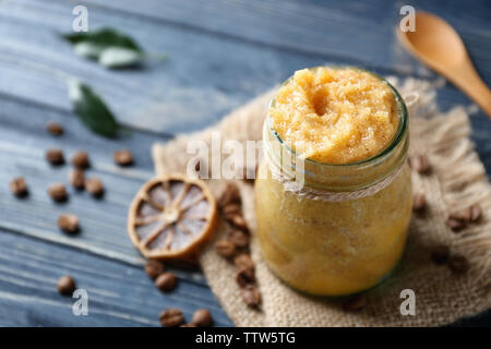 Vaso di vetro con lo scrubbing, essiccato fettina di limone e i chicchi di caffè su sfondo di legno Foto Stock