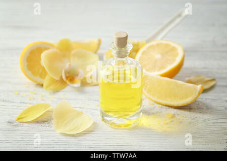 Bellissima spa composizione con l'olio essenziale di limone in bianco sullo sfondo di legno, primo piano Foto Stock