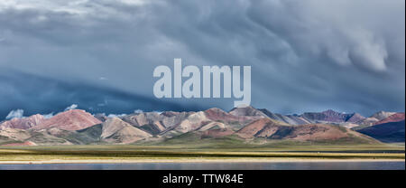 La gamma della montagna vicino a Nam Tso Lake, il Tibet (Cina, Asia). Nuvole nel cielo. Una tempesta potrebbe essere presto disponibile. Montagne colorate. Drammatico, mozzafiato. Foto Stock