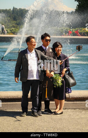 Famiglia asiatica prendendo le foto di graduazione a Drumheller Fountain, Università di Washington, Seattle campus, Seattle, Washington, Stati Uniti d'America Foto Stock