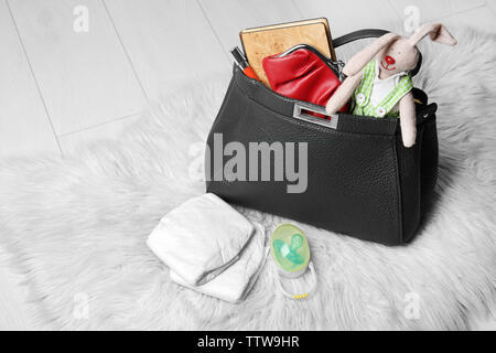 Le madri con borsa accessori sul morbido tappeto Foto Stock