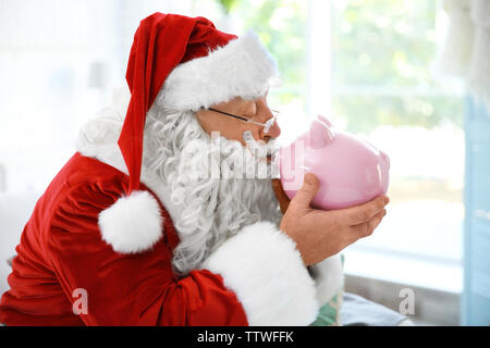 Babbo Natale con il salvadanaio a casa Foto Stock