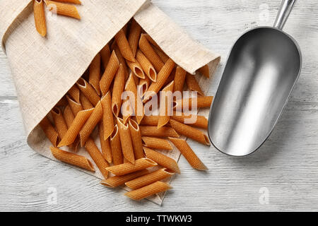 Convogliatore metallico con pasta su sfondo di legno Foto Stock