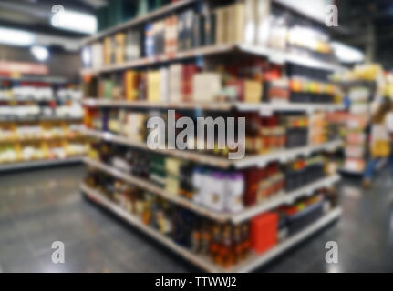 Sfocare lo sfondo di diversi tipi di alcol su scaffali in supermercato Foto Stock
