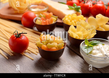 Diversi tipi di pasta su sfondo di legno Foto Stock