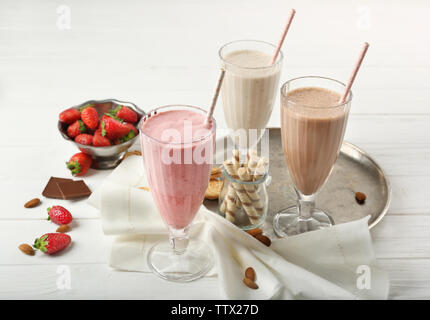 Gustosi cocktail con dolci e bacche su sfondo di legno Foto Stock