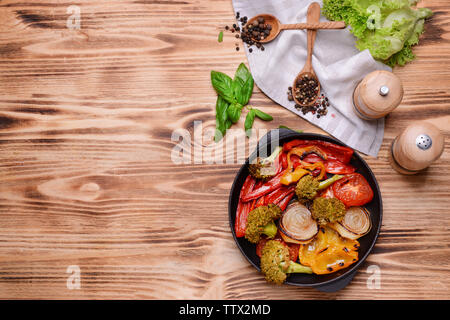 Ghisa padella con verdure alla griglia su sfondo di legno Foto Stock