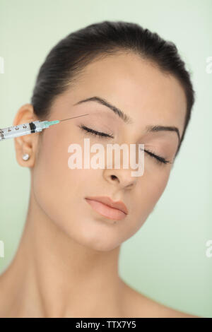 Donna che riceve iniezione di Botox nella palpebra Foto Stock