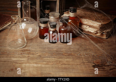 Vintage di palloni e bottiglie in vetro con ragnatela su sfondo di legno, primo piano Foto Stock