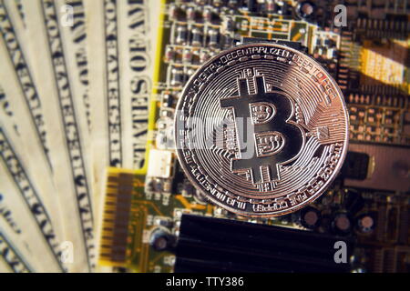 Argento moneta bitcoin con dollari e scheda madre del computer, cryptocurrency minerario e concetto di investimento Foto Stock