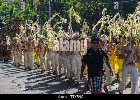 DENPASAR/BALI-Giugno 15 2019: Sampian ballerino, indossando giallo e bianco costume tradizionale, camminando per eseguire a Bali Arts Festival 2019. Essi utilizzano palm Foto Stock