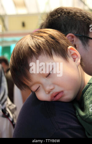 Ragazzo che dorme sulla spalla del padre, Malesia Foto Stock