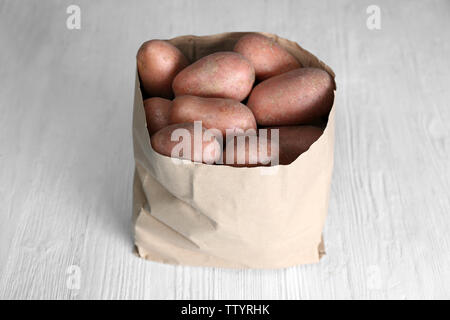 Sacchetto di patate fresche su sfondo di legno Foto Stock