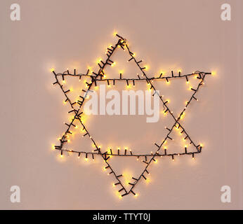 Stella di Davide realizzato da garland sulla parete. Hanukkah concept Foto Stock