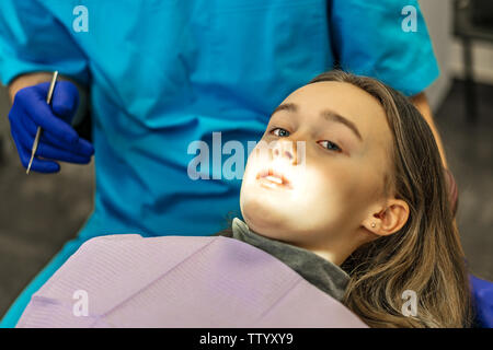 Dental Clinic. Reception, l'esame del paziente. La cura dei denti. Giovane donna subisce un esame dentale da un dentista Foto Stock