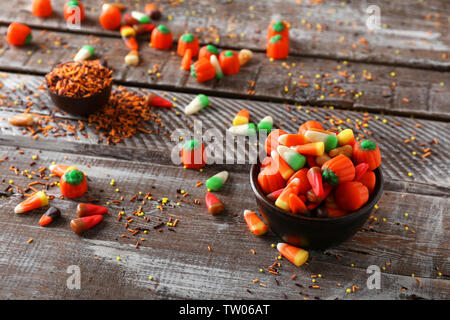 Concetto di Halloween. Caramelle colorate in una ciotola su sfondo di legno Foto Stock
