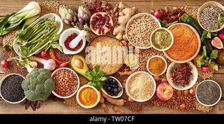 Bocce di cereali assortiti, legumi e delle sementi di ortaggi freschi e frutta in un close up top down vista panorama concettuale di una dieta sana o vege Foto Stock