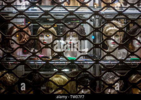 Parrucche visualizzato sul manichino teste in una vetrina di notte a Poznan, Polonia Foto Stock