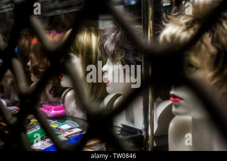 Parrucche visualizzato sul manichino teste in una vetrina di notte a Poznan, Polonia Foto Stock