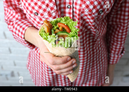 Donna che mantiene kebab delizioso rotolo, primo piano Foto Stock