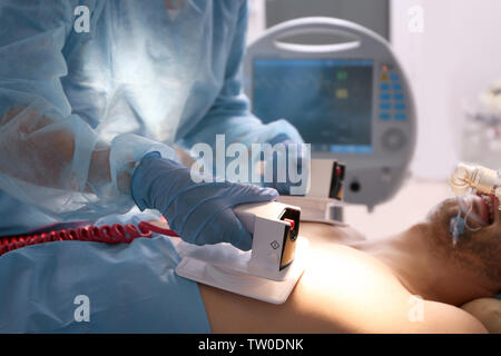 Medico nel tentativo di salvare la vita del paziente in clinica Foto Stock