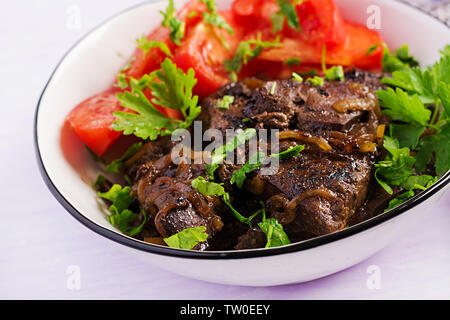 Arrosto o manzo alla griglia del fegato con cipolla e insalata di pomodori. Cucina medio-orientale. Foto Stock