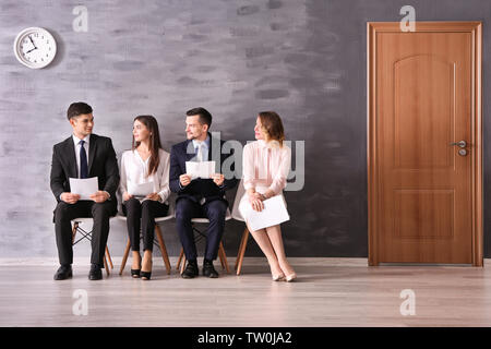 Un gruppo di persone in attesa per il colloquio di lavoro in interni Foto Stock