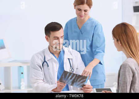 Medico mostra x-ray foto al paziente in clinica Foto Stock