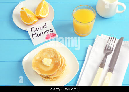 Una gustosa prima colazione e prendere nota di buona mattina sul tavolo da cucina Foto Stock