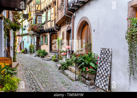 Case nel piccolo borgo vecchio Eguisheim, Alsazia, Francia, lane con case con travi di legno e decorazioni floreali Foto Stock