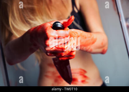 Bloody mani con coltello di premuto donna nella doccia Foto Stock